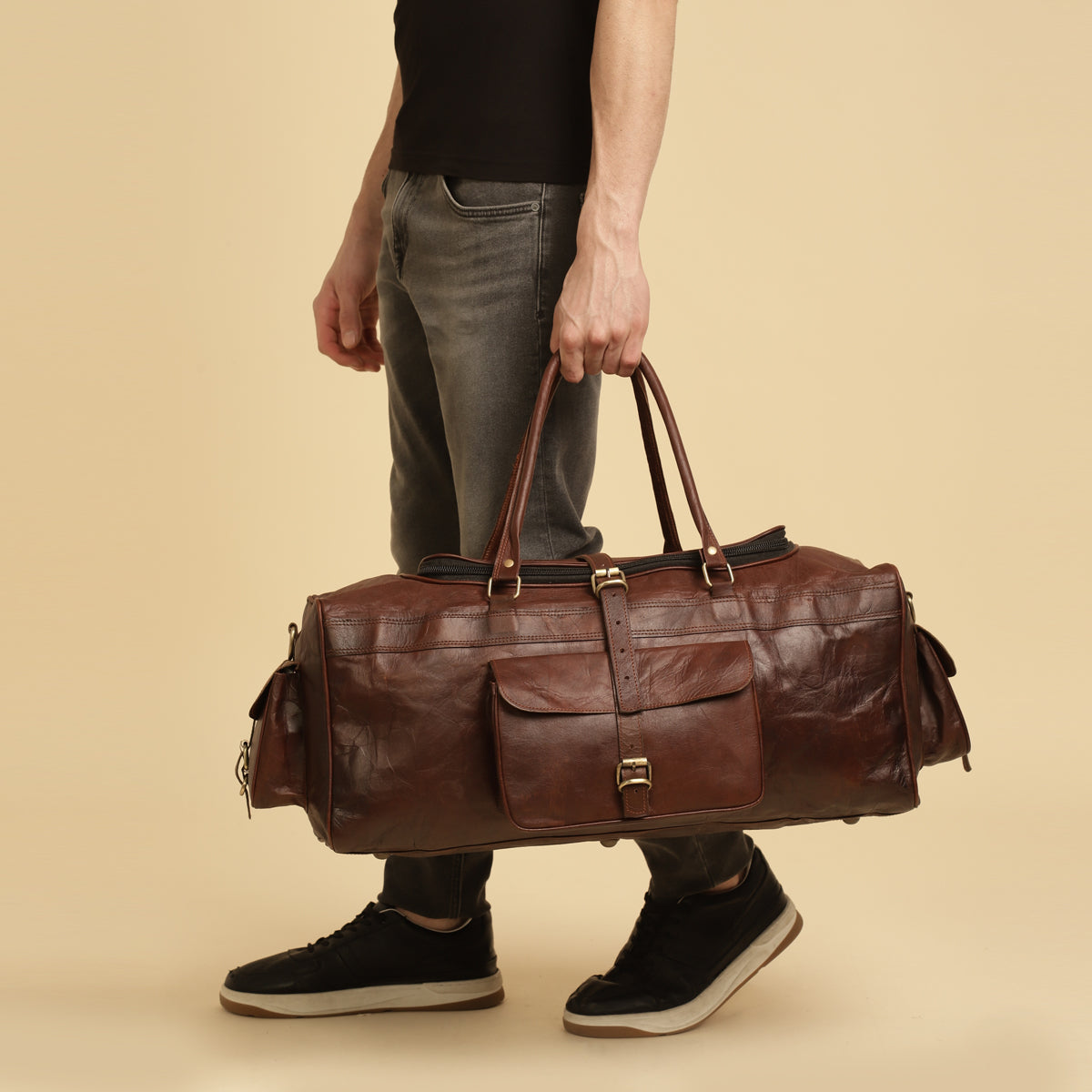 Model holding Red leather duffle bag